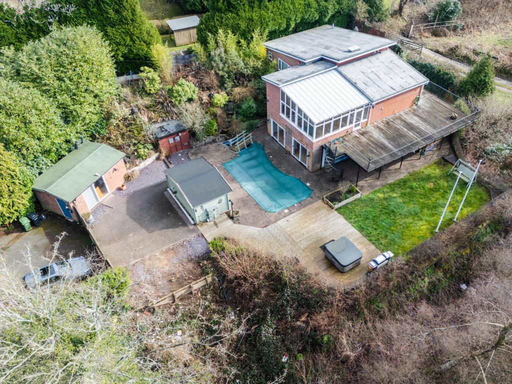 Lot: 164 - THREE-BEDROOM HOUSE IN SECLUDED LOCATION OVERLOOKING WOODLAND - View of detached property showing grounds and swimming pool